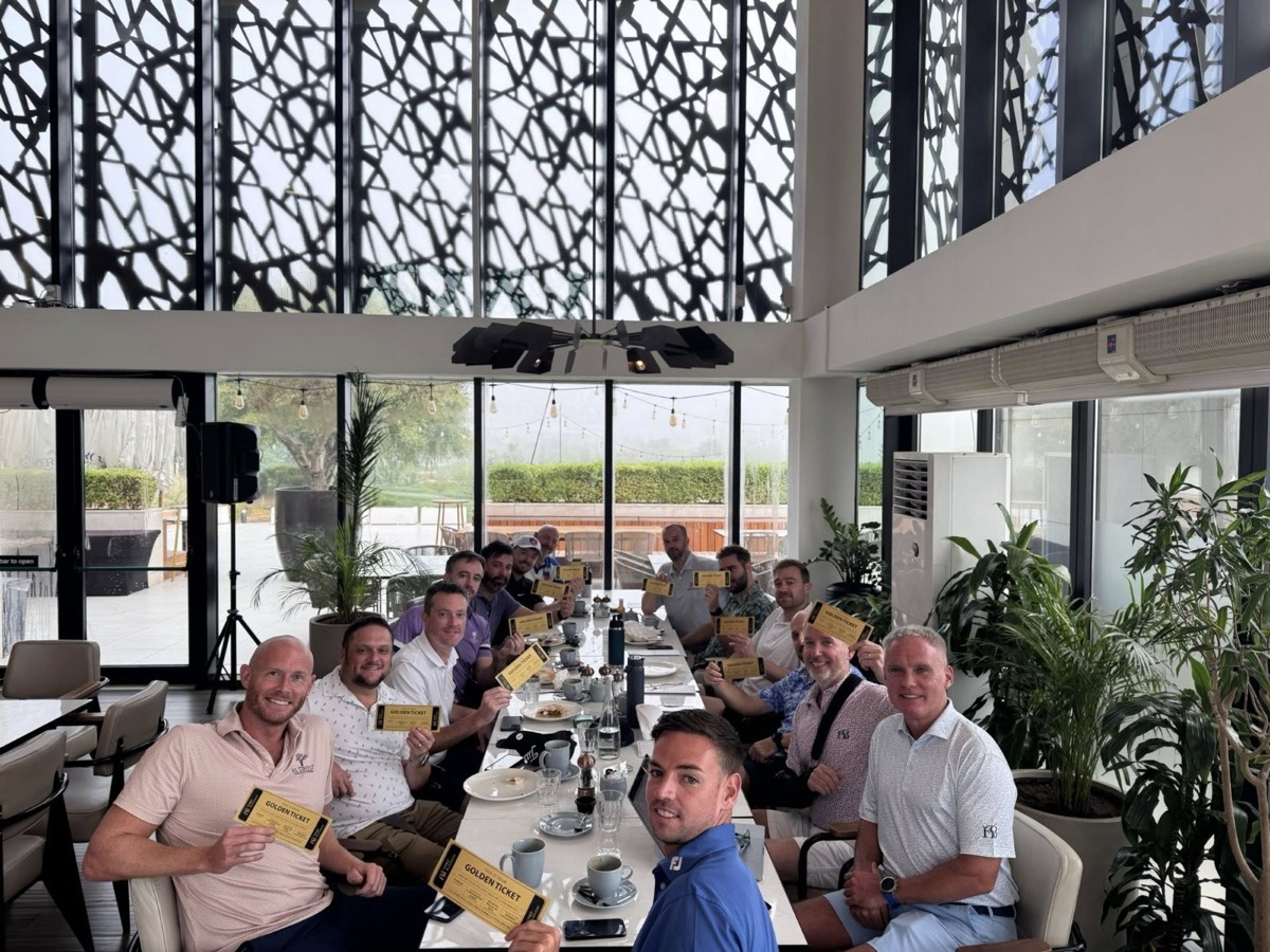 Members around the table before golf, holding their Golden Tickets